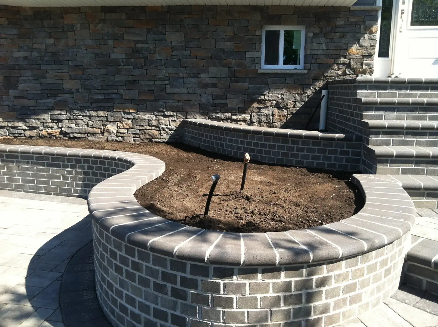 Curved stone planter wall Curved stone veneer planter wall in front of a home in Castle Rock, near Parker, CO