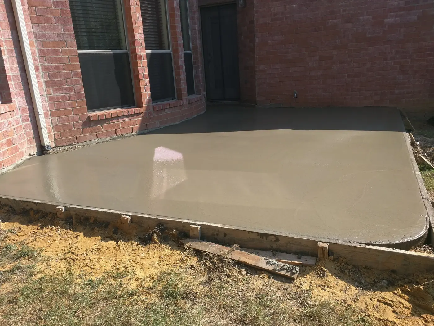 Fresh concrete patio pour Freshly poured concrete patio in forms beside a red brick home in Castle Rock, near Parker, CO