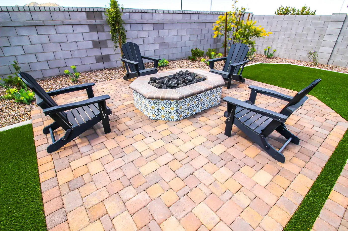 Paver patio with an octagonal tile-topped fire pit, Adirondack chairs and turf in Castle Pines, near Parker, CO