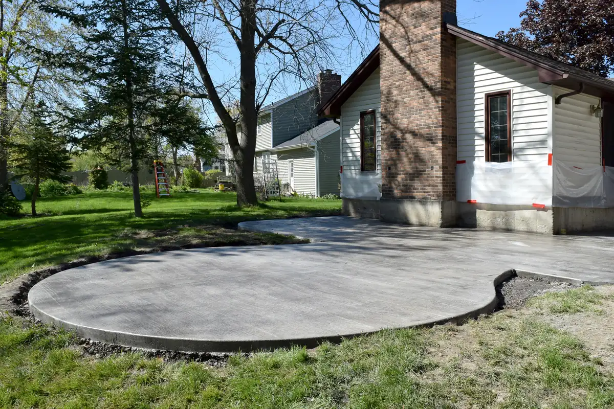 Round concrete patio Round poured concrete patio beside a white home under mature trees in The Pinery, near Parker, CO