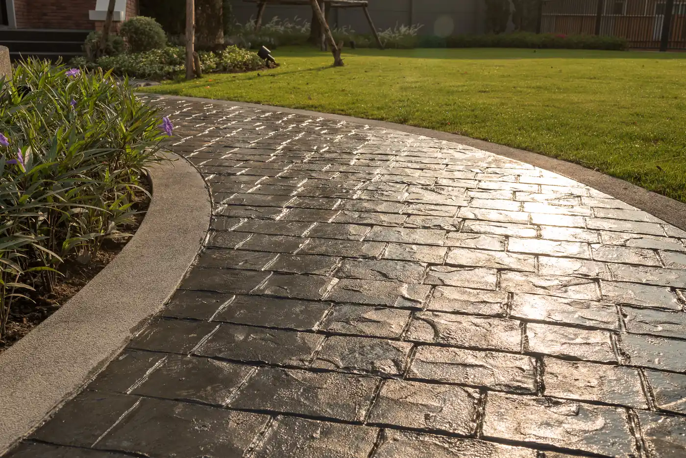 Stamped concrete pathway Curved stamped concrete pathway with a cobblestone texture through a lawn in Parker, CO