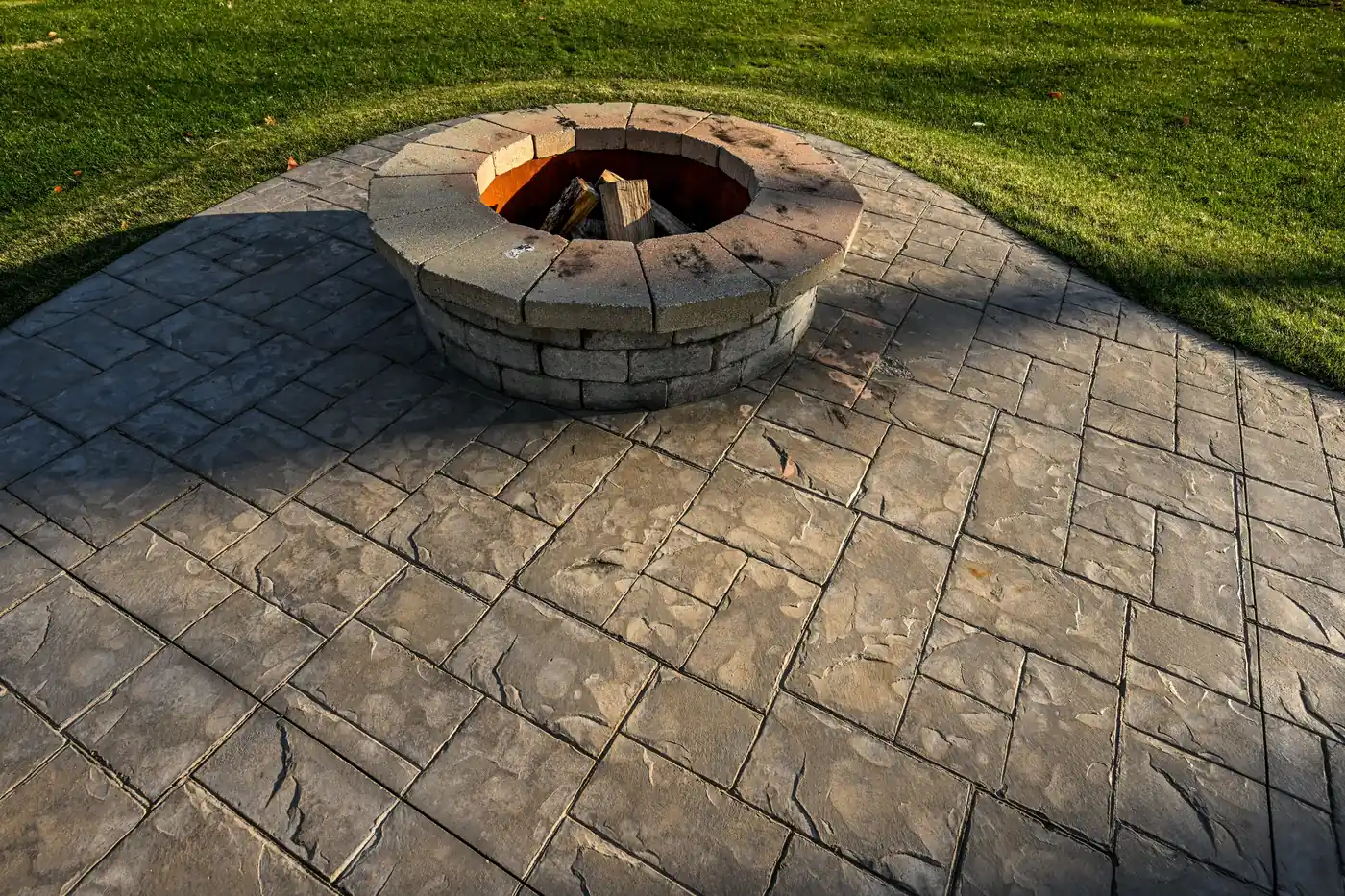 Stamped patio with fire pit Stamped concrete patio with a round stone fire pit at dusk in Castle Pines, near Parker, CO