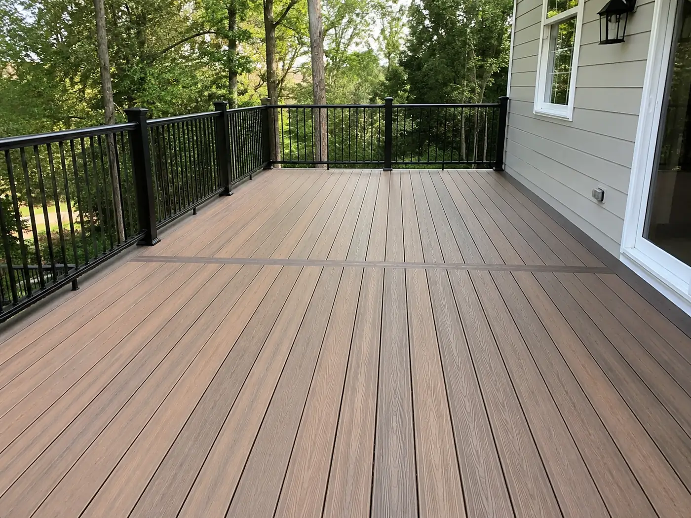 Wide composite deck Wide composite deck with black railing overlooking mature trees at a home in Parker, CO